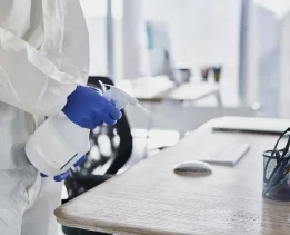 Close up human hands cleaning desk in the office